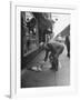 Man Bending over to Touch Cat Sitting on Sidewalk-Nina Leen-Framed Photographic Print