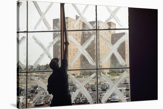 Man Cleaning Windows Near Housing Project-null-Stretched Canvas