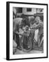 Man Fixing Basket on Bicycle as Children Watch Attentively-Nina Leen-Framed Photographic Print