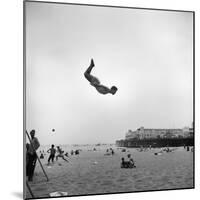 Man Flying Off a Trampoline at Santa Monica Beach-Loomis Dean-Mounted Photographic Print