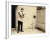 Man Is Sprinkling Boy with Water from Watering Can, 20th Century-Andrew Pitcairn-knowles-Framed Giclee Print