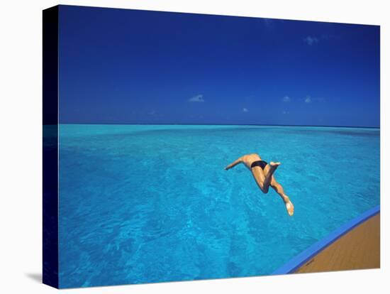 Man Jumping into Tropical Sea from Deck, Maldives, Indian Ocean-Papadopoulos Sakis-Stretched Canvas