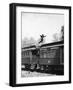 Man Leaping across the Roof of Railroad Cars-null-Framed Photo