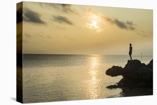 Man on a rock in backlight on the rocky west coast in Ouvea, Loyalty Islands, New Caledonia, Pacifi-Michael Runkel-Stretched Canvas