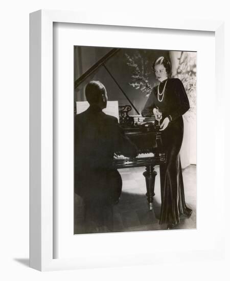 Man Plays a Piano and Looks up at a Glamorous Woman in a Long Dress-null-Framed Photographic Print