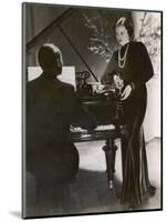 Man Plays a Piano and Looks up at a Glamorous Woman in a Long Dress-null-Mounted Photographic Print