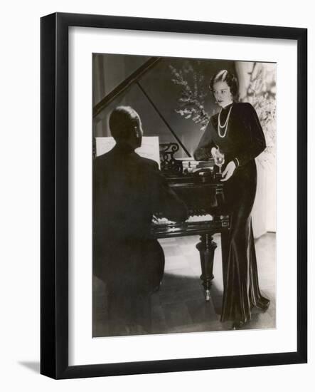 Man Plays a Piano and Looks up at a Glamorous Woman in a Long Dress-null-Framed Photographic Print