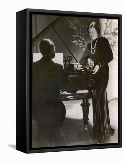 Man Plays a Piano and Looks up at a Glamorous Woman in a Long Dress-null-Framed Stretched Canvas