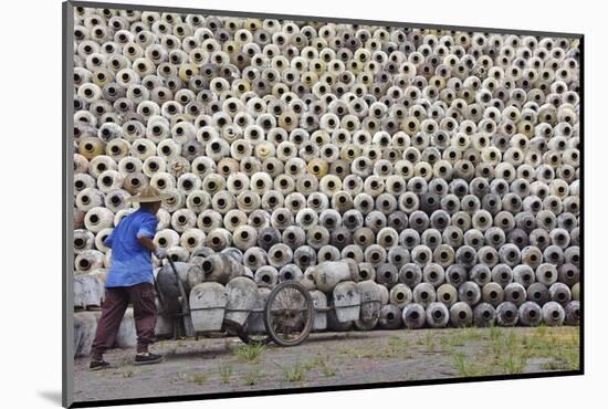 Man pushing cart loaded with wine jars to the big pile in a winery, Zhejiang Province, China-Keren Su-Mounted Photographic Print
