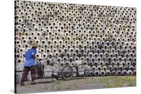 Man pushing cart loaded with wine jars to the big pile in a winery, Zhejiang Province, China-Keren Su-Stretched Canvas