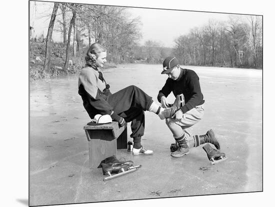 Man Putting on Woman's Ice Skates-Philip Gendreau-Mounted Photographic Print