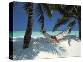 Man Relaxing on a Beachside Hammock, Maldives, Indian Ocean-Papadopoulos Sakis-Stretched Canvas