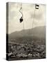 Man Riding Chair Lift Above Town-Jerry Cooke-Stretched Canvas