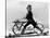 Man Riding Early Bicycle-null-Stretched Canvas