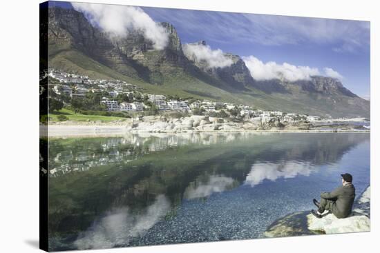 Man Sits on Rock Facing Twelve Apostles Mountain Reflected in Atlantic Ocean, Camp's Bay, Cape Town-Kimberly Walker-Stretched Canvas