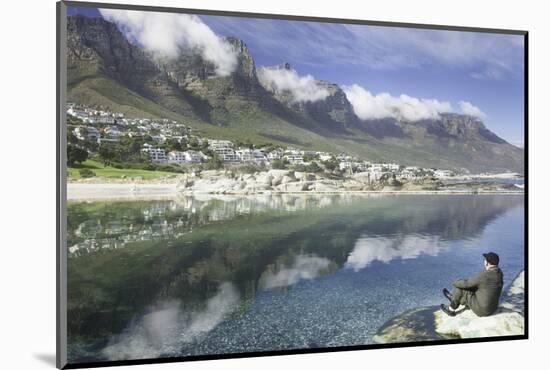 Man Sits on Rock Facing Twelve Apostles Mountain Reflected in Atlantic Ocean, Camp's Bay, Cape Town-Kimberly Walker-Mounted Photographic Print