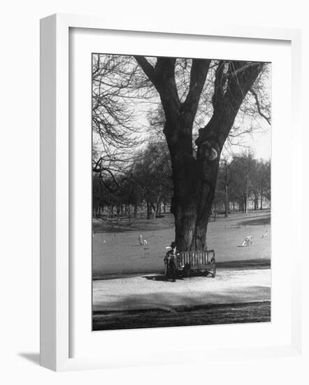 Man Sitting on a Bench and Reading a Newspaper in the Park-Cornell Capa-Framed Photographic Print