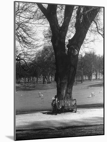 Man Sitting on a Bench and Reading a Newspaper in the Park-Cornell Capa-Mounted Photographic Print