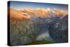 Man standing on rocks looking at clouds at sunset over lake Limmernsee, aerial view-Roberto Moiola-Stretched Canvas