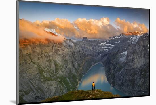 Man standing on rocks looking at clouds at sunset over lake Limmernsee, aerial view-Roberto Moiola-Mounted Photographic Print