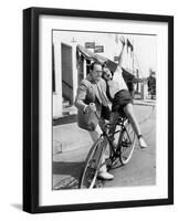 Man Trying to Balance an Exuberant Woman on a Bicycle-null-Framed Photo