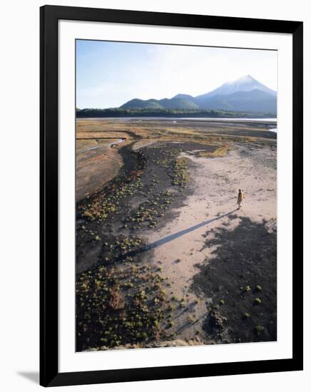 Man Walking on Dry Lake Bed with Llaima Volcano in Distance, Conguillio National Park, Chile-Aaron McCoy-Framed Photographic Print