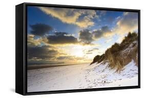 Man Walks Dog on Snow Covered Bamburgh Beach at Dawn with View to Farne Islands-Eleanor-Framed Stretched Canvas