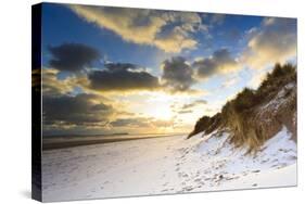 Man Walks Dog on Snow Covered Bamburgh Beach at Dawn with View to Farne Islands-Eleanor-Stretched Canvas