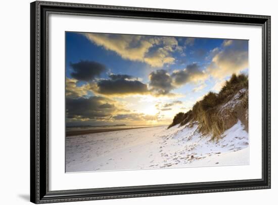 Man Walks Dog on Snow Covered Bamburgh Beach at Dawn with View to Farne Islands-Eleanor-Framed Photographic Print