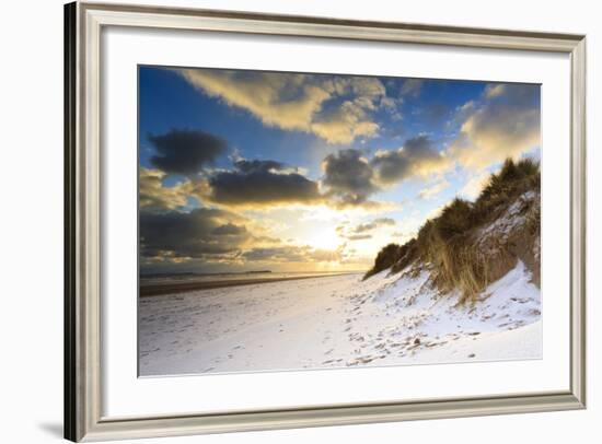 Man Walks Dog on Snow Covered Bamburgh Beach at Dawn with View to Farne Islands-Eleanor-Framed Photographic Print