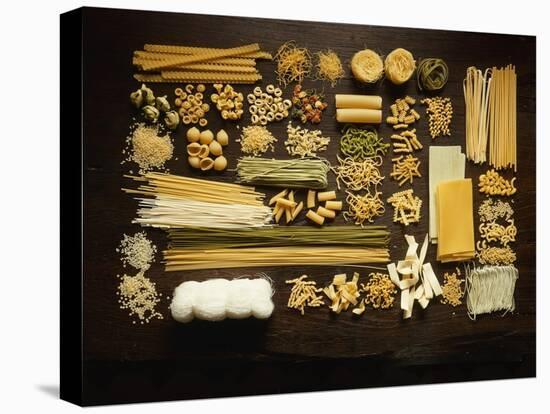 Many Different Types of Pasta on Dark Wooden Background-Walter Cimbal-Stretched Canvas