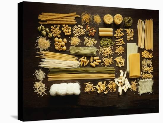 Many Different Types of Pasta on Dark Wooden Background-Walter Cimbal-Stretched Canvas