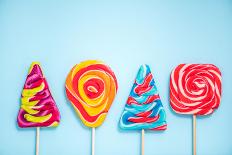 Colorful Vibrant Lollipops, Flat Lay on Blue Background-Marcin Jucha-Photographic Print
