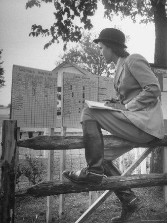 Betty Jane Baldwin Sitting on Fence and Looking at Official Board at Warrenton Horse Show
