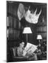 Member Reading Newspaper in Smoking Room at the Harvard Club Beneath a Rhino Head Trophy-Alfred Eisenstaedt-Mounted Photographic Print