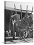 Men Constructing a Wheat Wreath Behind a Wheat Filled Wagon During the Harvest Season-Hans Wild-Stretched Canvas