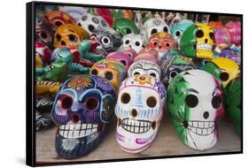 Mexico, Yucatan, Isla Mujeres, colorful ceramic calavera skulls for sale in market.-Merrill Images-Framed Stretched Canvas