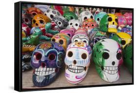 Mexico, Yucatan, Isla Mujeres, colorful ceramic calavera skulls for sale in market.-Merrill Images-Framed Stretched Canvas