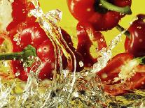 Peppers Falling into Water Against Yellow Background-Michael Meisen-Photographic Print