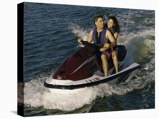 Mid Adult Couple Riding a Jet Ski-null-Stretched Canvas