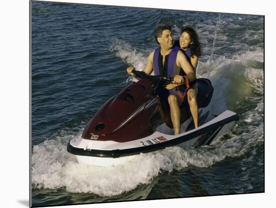 Mid Adult Couple Riding a Jet Ski-null-Mounted Photographic Print