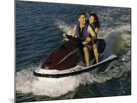 Mid Adult Couple Riding a Jet Ski-null-Mounted Photographic Print