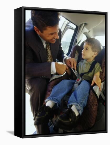 Mid Adult Man Strapping His Son into a Car-null-Framed Stretched Canvas