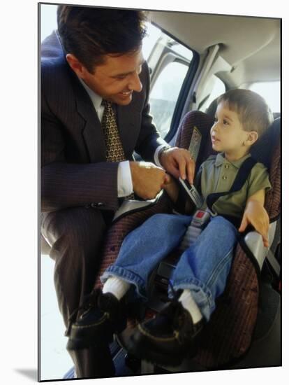 Mid Adult Man Strapping His Son into a Car-null-Mounted Premium Photographic Print