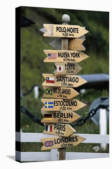 Mileage Sign Pointing Directions in Puerto Williams-Paul Souders-Stretched Canvas