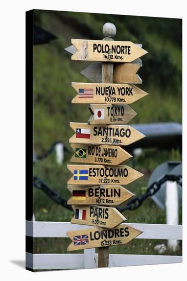 Mileage Sign Pointing Directions in Puerto Williams-Paul Souders-Stretched Canvas