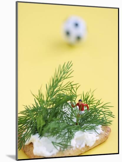 Miniature Footballer Fighting His Way Through Forest of Dill-Martina Schindler-Mounted Photographic Print