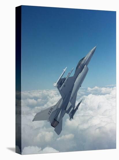 Missile-Armed Us F-16 Fighter Aircraft in Flight, Climbing Above Clouds-null-Stretched Canvas