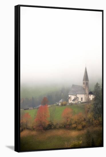 Mist and colourful trees surround the alpine church in the fall, St. Magdalena, Funes Valley, South-Roberto Moiola-Framed Stretched Canvas