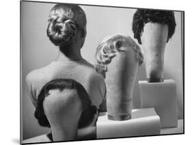 Model Vikki Dougan Wearing Attachable Bun of Extra Hair, Next to Other Wigs-Nina Leen-Mounted Photographic Print